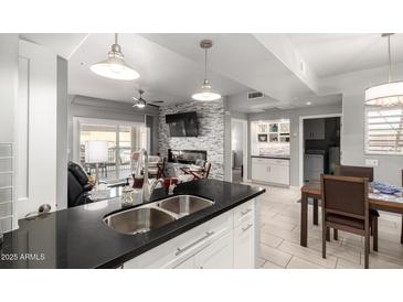 Modern living room with open floor plan, fireplace, and island with dark granite countertops at 13700 N Fountain Hills Blvd # 135, Fountain Hills, AZ 85268