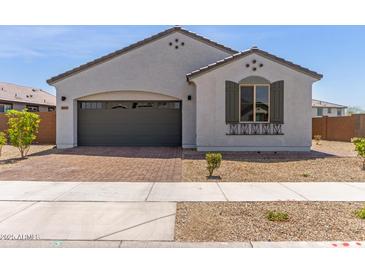 Charming single-story home with a brick driveway, gray stucco, and neat landscaping at 14269 W El Cortez Pl, Surprise, AZ 85387