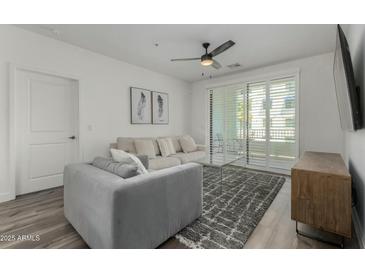 Bright living room boasts neutral tones, modern ceiling fan, plush seating, and access to a balcony at 2511 W Queen Creek Rd # 266, Chandler, AZ 85248