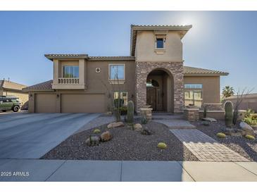 Inviting two-story home with stone accents, desert landscaping, and a spacious three-car garage at 27316 N Covered Wagon Rd, Phoenix, AZ 85085