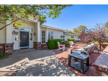 Inviting front entrance with a covered porch, brick accents, and comfortable seating area at 4030 N 54Th Pl, Phoenix, AZ 85018