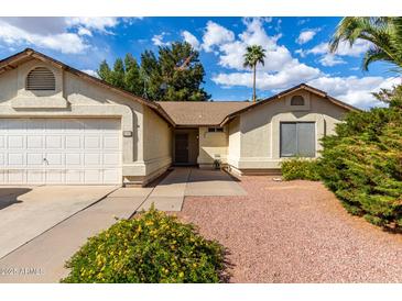 Inviting single-story home with a well-maintained yard, two-car garage, and desert landscaping at 4102 W Fallen Leaf Ln, Glendale, AZ 85310