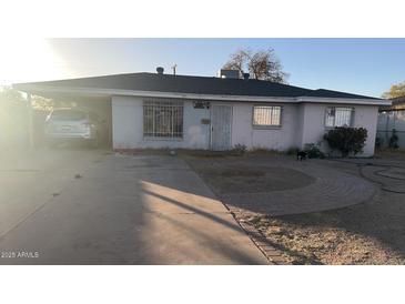Charming single-story home with a car in a covered carport and a paved walkway to the front door at 4146 N 48Th Dr, Phoenix, AZ 85031