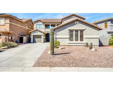 Charming two-story home with desert landscaping and a spacious driveway leading to a three-car garage at 44314 W Mescal St, Maricopa, AZ 85138