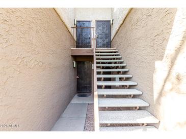 Exterior shot of a condo building with light colored stucco and front doors with wrought iron decoration at 4554 E Paradise Village N Pkwy # 210, Phoenix, AZ 85032