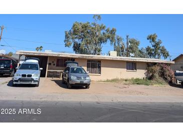 Modest single-story home with a brick facade, set against a clear blue sky at 5520 W Clarendon Ave, Phoenix, AZ 85031