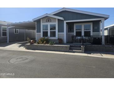 Charming single-story home featuring a cozy front porch, carport, and landscaped garden bed at 650 N Hawes Rd # 3123, Mesa, AZ 85207