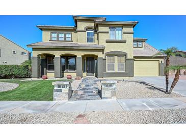 Two-story home with stone accents, tile roof, and arched entry offers an inviting facade at 248 S 167Th Dr, Goodyear, AZ 85338