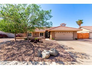 Charming single-story home featuring a two car garage, desert landscaping, and a red tile roof at 2753 E Kenwood St, Mesa, AZ 85213