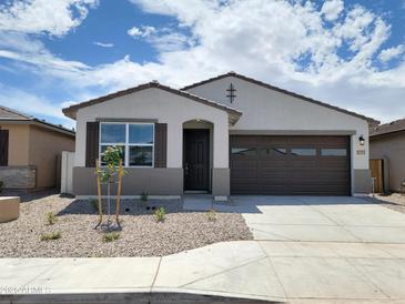 Charming single-story home featuring a two-car garage and low-maintenance desert landscaping at 37111 W Prado St, Maricopa, AZ 85138