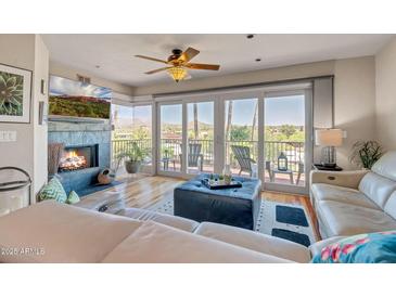 Bright living room features a fireplace, ceiling fan, balcony access with fantastic views of mountains at 37300 N Tom Darlington Dr # D, Carefree, AZ 85377