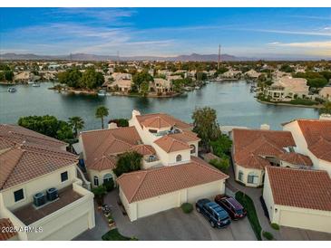 Stunning aerial view of waterfront homes with tile roofs, lush landscaping, and access to a serene lake community at 1700 E Lakeside Dr # 12, Gilbert, AZ 85234