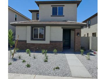 Charming two-story home with a stone-accented facade and low-maintenance landscaping at 15587 S 180Th Ln, Goodyear, AZ 85338