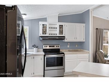 Charming kitchen with white cabinetry, stainless steel appliances, and plenty of counter space at 201 S Greenfield Rd # 51, Mesa, AZ 85206