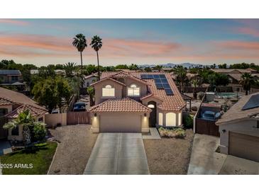 Inviting two-story home boasting a red-tile roof, solar panels, and well-manicured landscaping for a desirable curb appeal at 12745 W Monte Vista Rd, Avondale, AZ 85392