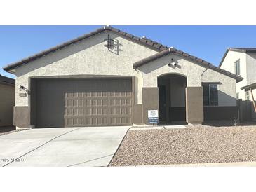 Charming single-story home with a neutral color scheme, attached two-car garage, and low-maintenance gravel landscaping at 25336 W Bowker St, Buckeye, AZ 85326