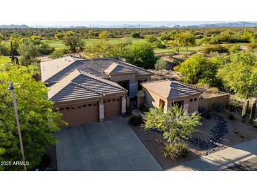 Aerial view of desert home and golf course with a large driveway and a two-car garage at 23014 N 52Nd St, Phoenix, AZ 85054