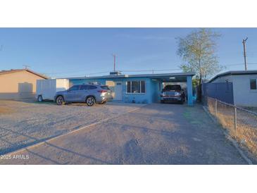 Charming single-story home featuring light blue paint, a covered carport, and low-maintenance desert landscaping at 2305 E Southern Ave, Phoenix, AZ 85040