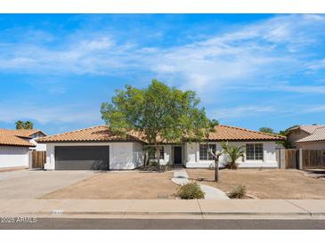 Charming single-story home featuring a tile roof and a mature tree in the front yard at 2640 E Mallory St, Mesa, AZ 85213