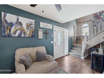 Cozy living room featuring comfortable seating and stylish decor with a staircase to the upper floor at 3732 W Bluefield Ave, Glendale, AZ 85308