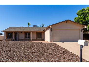 Charming home with a two-car garage, neutral colors and low-maintenance gravel landscaping in front at 3828 W Crocus Dr, Phoenix, AZ 85053