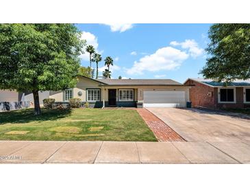 Charming single-story home featuring a well-manicured lawn and a two-car garage at 4034 E Aster Dr, Phoenix, AZ 85032