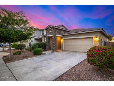 Charming home boasts stone accents, a two-car garage, and nicely landscaped front yard at 5752 N 109Th Ave, Phoenix, AZ 85037