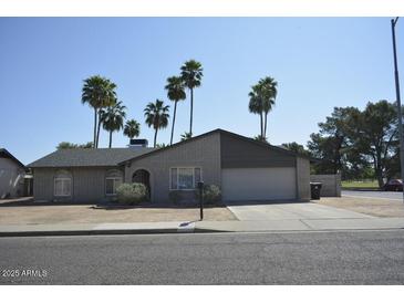 Charming single-story home featuring a brick facade, attached garage, and well-maintained landscaping with mature palm trees at 12601 N 34Th St, Phoenix, AZ 85032