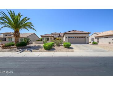 Charming single-story home with a two-car garage, desert landscaping, and a well-manicured lawn at 15134 W Waterford Dr, Surprise, AZ 85374