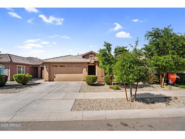 Charming single-story home featuring a desert landscape, two-car garage, and inviting curb appeal at 16396 W Questa Dr, Surprise, AZ 85387