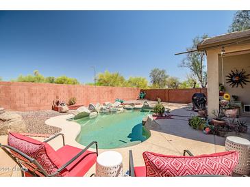 Inviting backyard pool with rock accents and a serene desert landscape, perfect for relaxation and outdoor enjoyment at 16924 W Stevenage St, Surprise, AZ 85374
