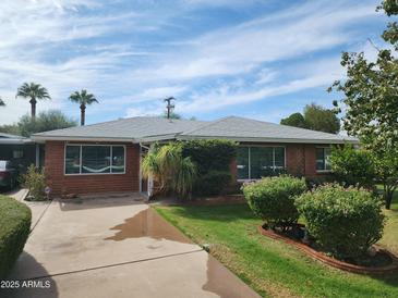 Charming single-story brick home with well-maintained landscaping and a spacious driveway at 1945 E Solano Dr, Phoenix, AZ 85016