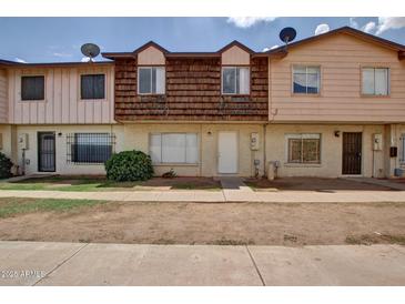 Modest townhouse featuring a tidy front lawn and classic architectural details at 3605 W Bethany Home Rd # 7, Phoenix, AZ 85019