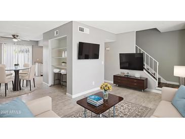 Bright living room showcasing an open floor plan with wood floors, modern décor, and a stairway to the second level at 3605 W Bethany Home Rd # 7, Phoenix, AZ 85019