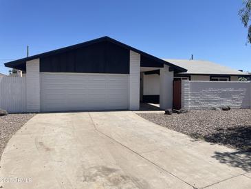 Home exterior featuring a white garage door and monochromatic color scheme with low maintenance desert landscaping at 4210 W Solano Dr, Phoenix, AZ 85019