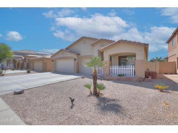 Charming single-story home with a well-manicured yard, desert landscaping, and a two-car garage at 46141 W Amsterdam Rd, Maricopa, AZ 85139