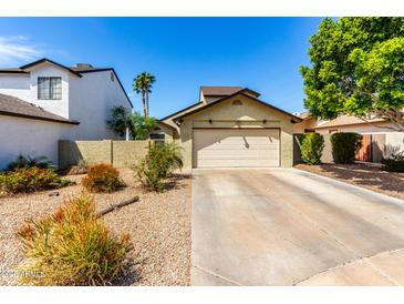 Charming home featuring a tan stucco facade, low maintenance landscaping, and two-car garage at 542 N Orlando Cir, Mesa, AZ 85205