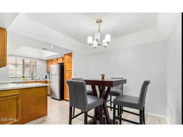 This cozy dining area features a modern chandelier and stylish gray chairs, perfect for intimate meals at 700 E Mesquite Cir # N125, Tempe, AZ 85288