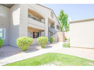 Three-story condo building with well-maintained landscaping and exterior stairs to upper units at 7009 E Acoma Dr # 1160, Scottsdale, AZ 85254