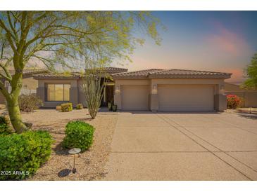 Inviting single-story home with a neutral color scheme, three-car garage, and desert landscaping at 9747 S 182Nd Dr, Goodyear, AZ 85338