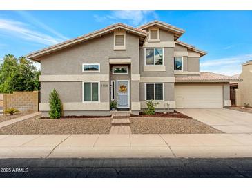Charming two-story home featuring a well-manicured front yard, gray exterior, and a welcoming entrance with a lovely wreath at 1138 E Liberty Shores Dr, Gilbert, AZ 85234