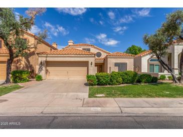 Charming single-story home with a two-car garage, beautiful landscaping, and a terracotta tile roof at 221 N Ironwood St, Gilbert, AZ 85234