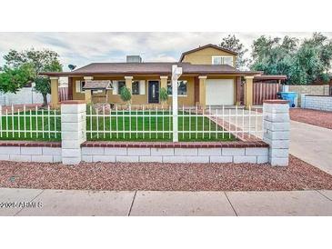 Charming single-Gathering home with a well-maintained lawn, decorative front fence, and covered entryway at 3121 W Greenway Rd, Phoenix, AZ 85053