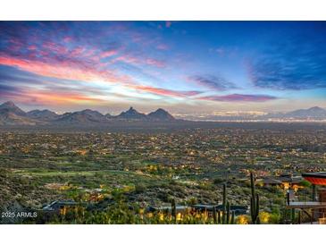Breathtaking sunset view from this hillside home overlooking city lights and mountain ranges at 43105 N 102Nd St, Scottsdale, AZ 85262