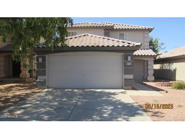Two-story home featuring a large two car garage, tile roof, and a concrete driveway at 11218 W Glenrosa Ave, Phoenix, AZ 85037