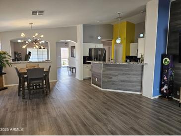 Spacious living space featuring wood flooring, modern lighting, and open floor plan at 11760 N 153Rd Ave, Surprise, AZ 85379