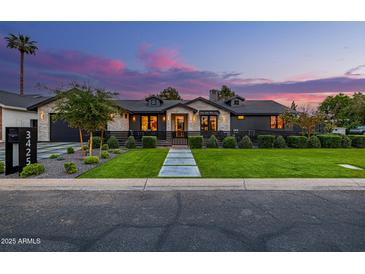 Striking exterior elevation with manicured lawn, black trim, and contrasting brick accents at dusk at 3425 N 50Th Pl, Phoenix, AZ 85018