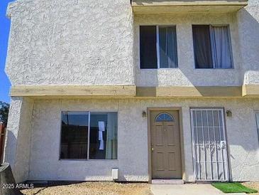 Two-story townhome featuring a neutral-colored stucco exterior, complemented by large windows for ample natural light at 3840 N 43Rd Ave # 71, Phoenix, AZ 85031