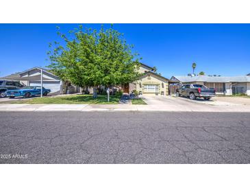 Charming single-story home featuring a well-manicured lawn and mature shade tree in a quiet neighborhood setting at 4112 E Maldonado Dr, Phoenix, AZ 85042