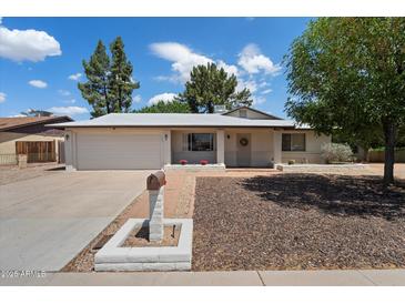 Charming single-story home featuring a spacious front yard with mature trees and a two-car garage at 4744 W Altadena Ave, Glendale, AZ 85304